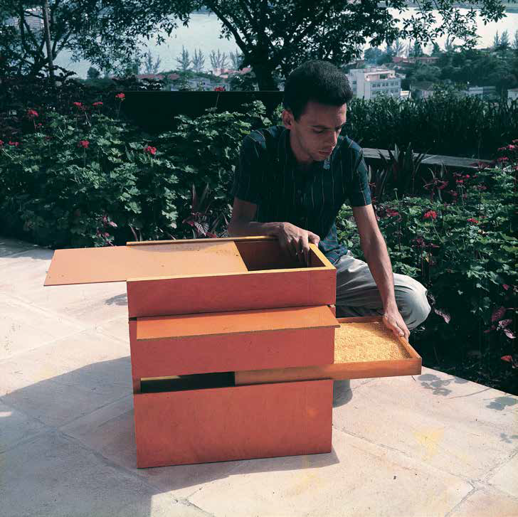 Hélio Oiticica manipulando o trabalho B 11 Bólide caixa 09 (1964) em sua residência na rua Engenheiro Alfredo Duarte, Rio de Janeiro, década de 1960