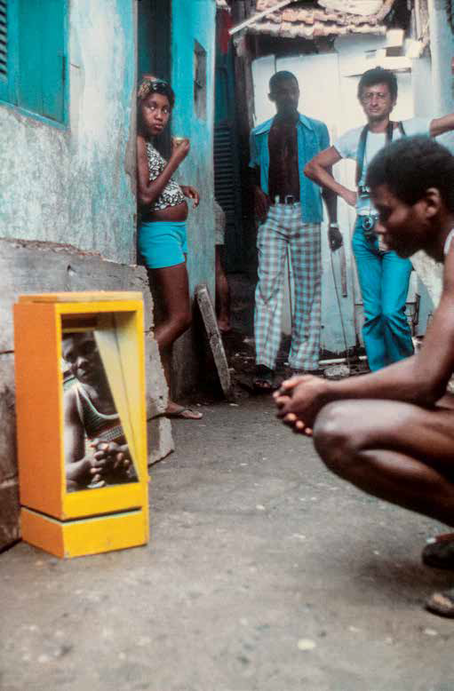 Morador do morro da Mangueira, no Rio de Janeiro, observando o seu reflexo no B 09 Bólide caixa 07 (1964) de Hélio Oiticica, 1979
